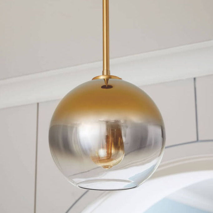Nordic gradient glass globe pendant light glowing over a table