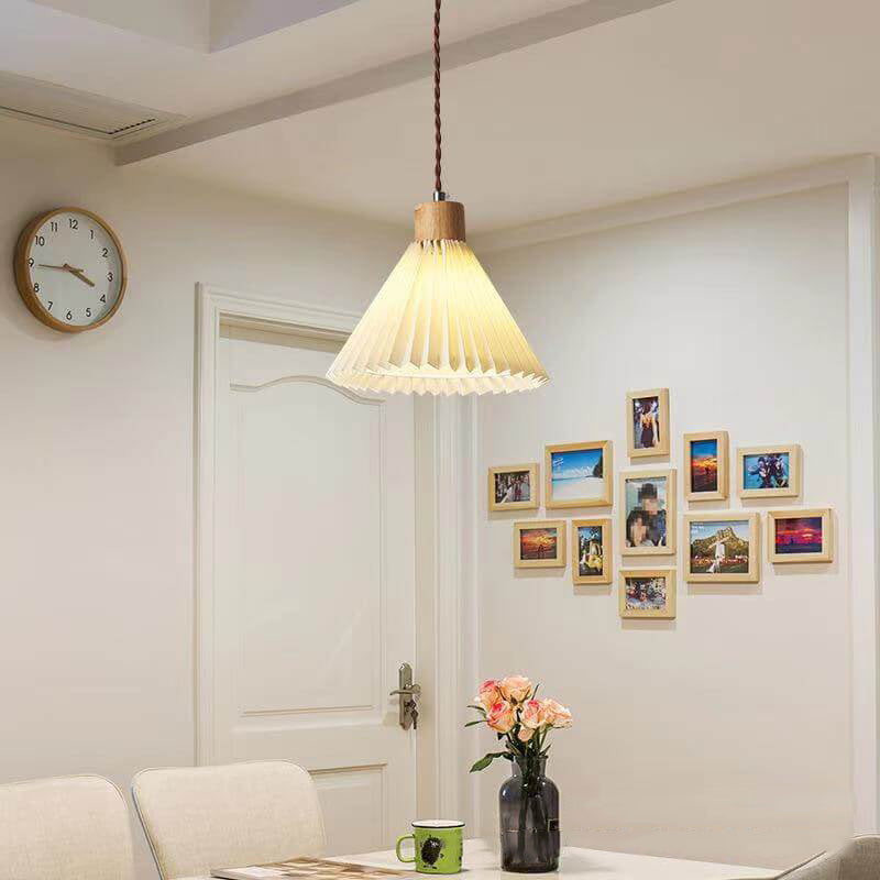 Pleated fabric shade pendant light glowing softly over a table